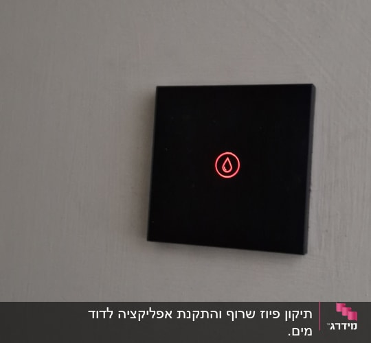 מתג חשמלי עם תאורה אדומה על קיר